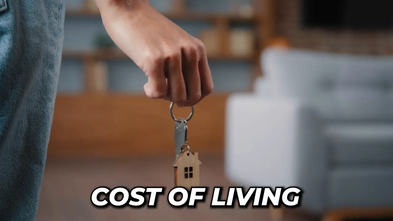 Hand holding house keys with cost of living text