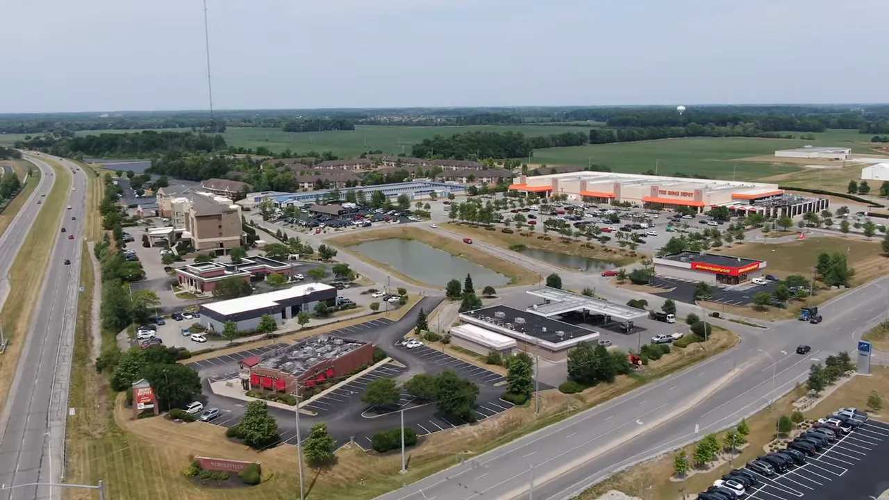 Aerial photo of big-box stores, parking lots and surrounding roads in a suburban commercial area