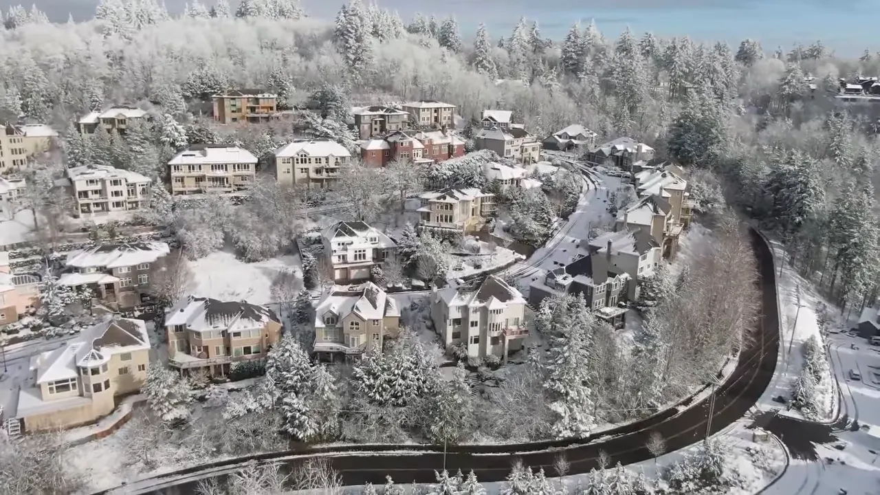 Snow-covered Forest Heights homes and winding hillside roads