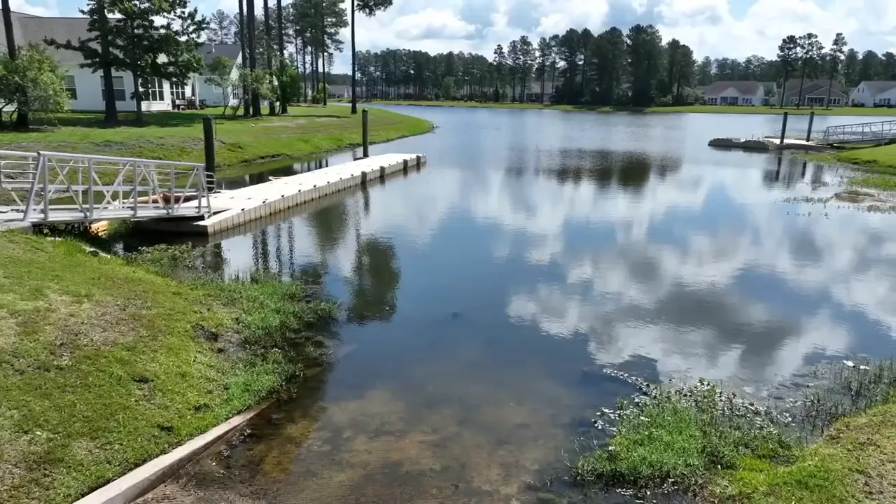 Calm lake with dock and surrounding homes in Cane Bay area