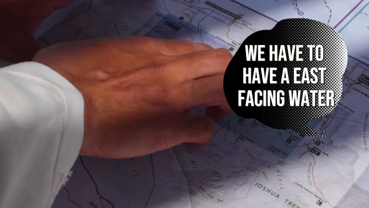 Close-up of hands and a lot map with text highlighting east-facing considerations