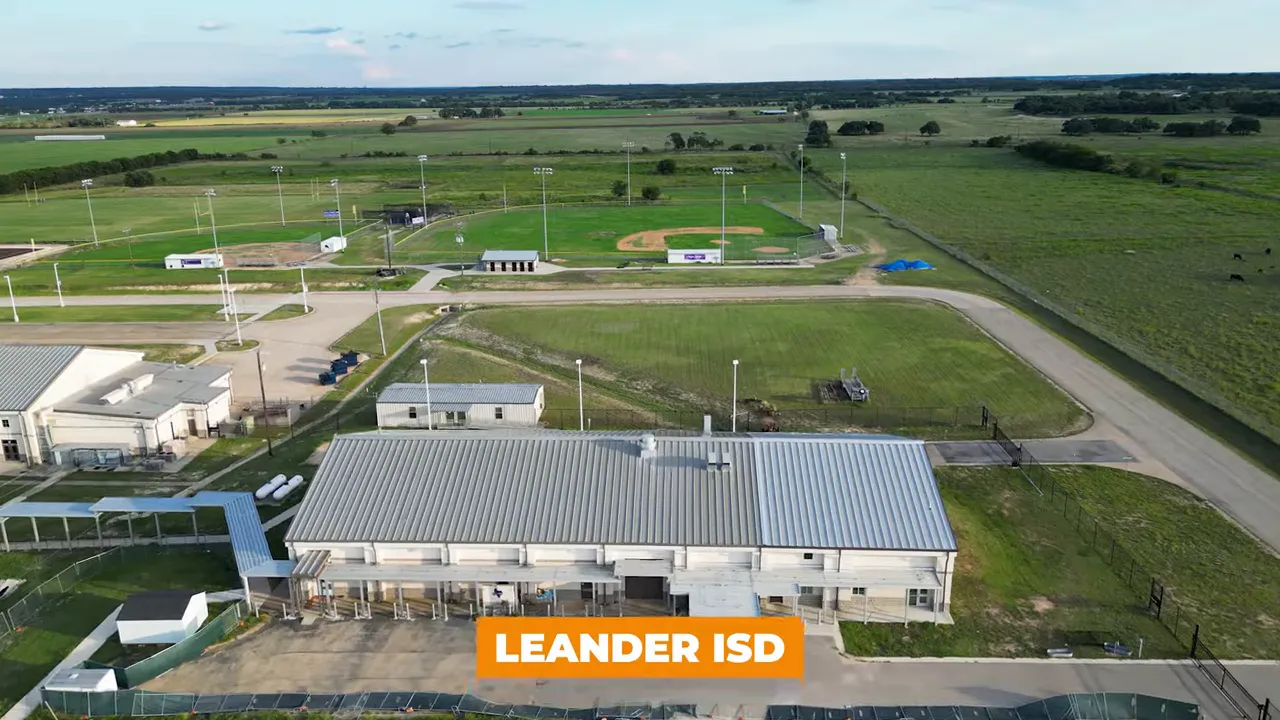 Aerial view showing school athletic fields and buildings with an orange overlay reading 'LEANDER ISD'.