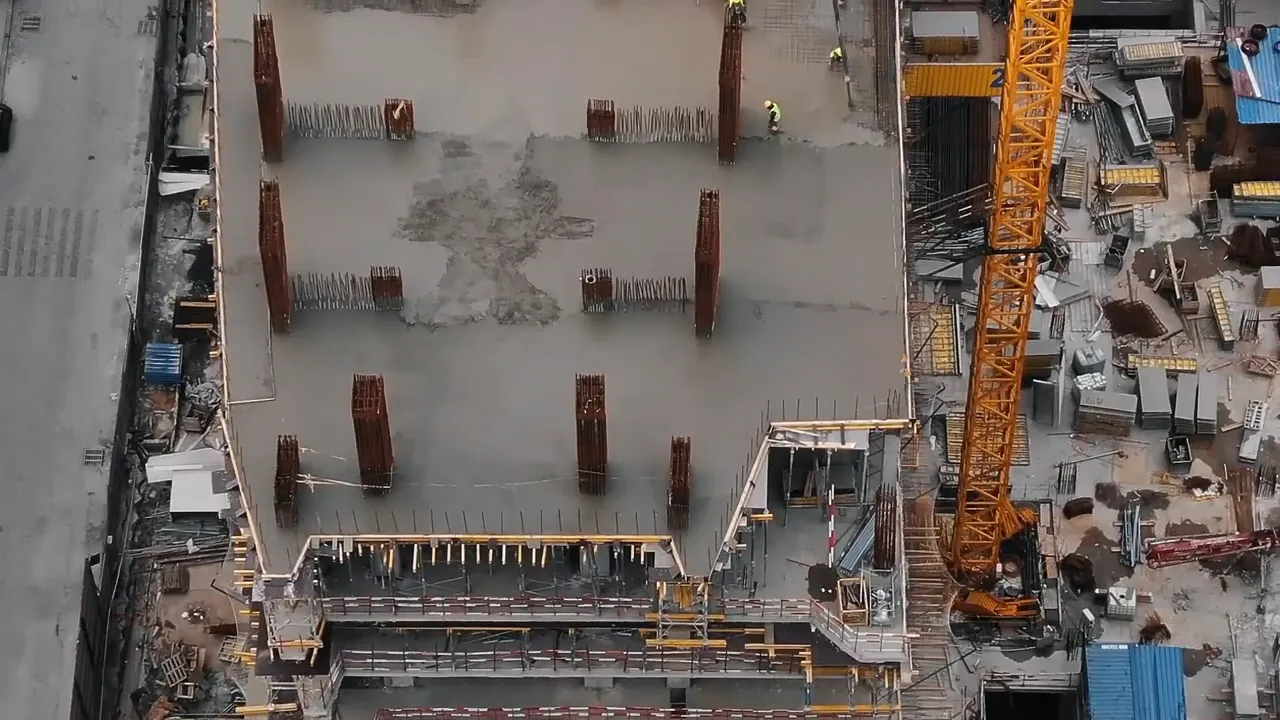 Aerial view of a large construction site with crane and concrete structure