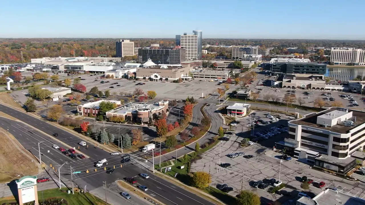 aerial drone view of a suburban shopping center, parking lots, and arterial roads near Indianapolis