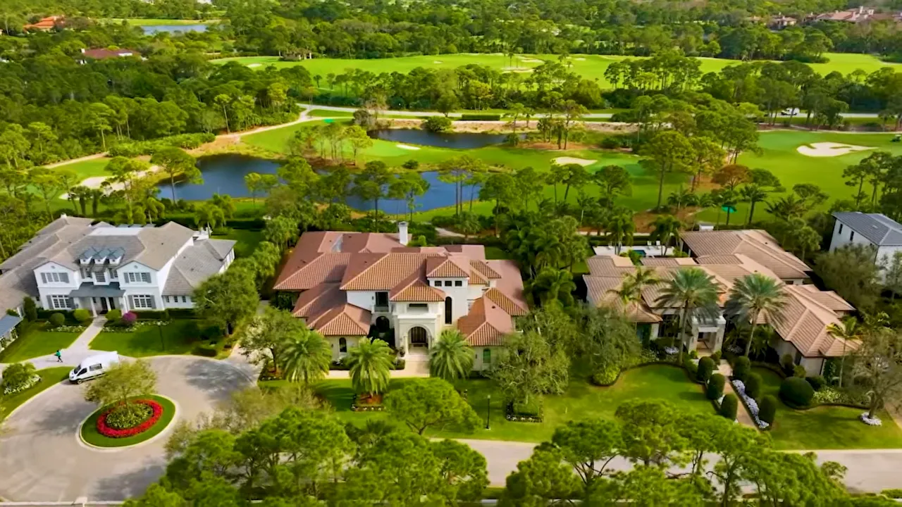 Aerial view of large estates surrounded by dense trees near a golf course
