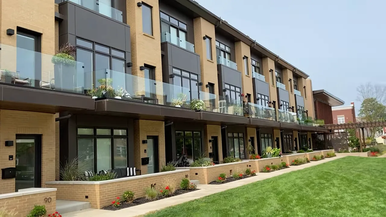 Modern row of attached townhomes with balconies and landscaped front walk