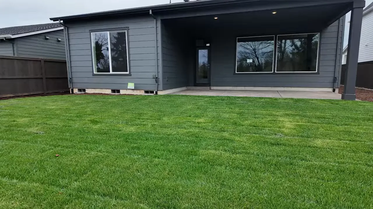 Single-family home with a large, grassy backyard and covered entry area at Mark’s Place at Tofte Farms