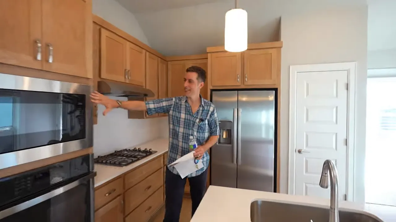 Kitchen with island wood cabinets stainless appliances and open living area beyond