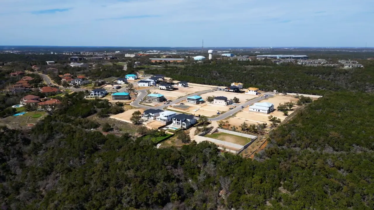 Aerial view of a small luxury home community surrounded by wooded land