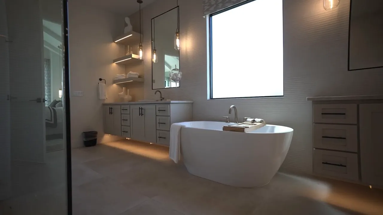 Primary bathroom with freestanding tub glass shower and large window