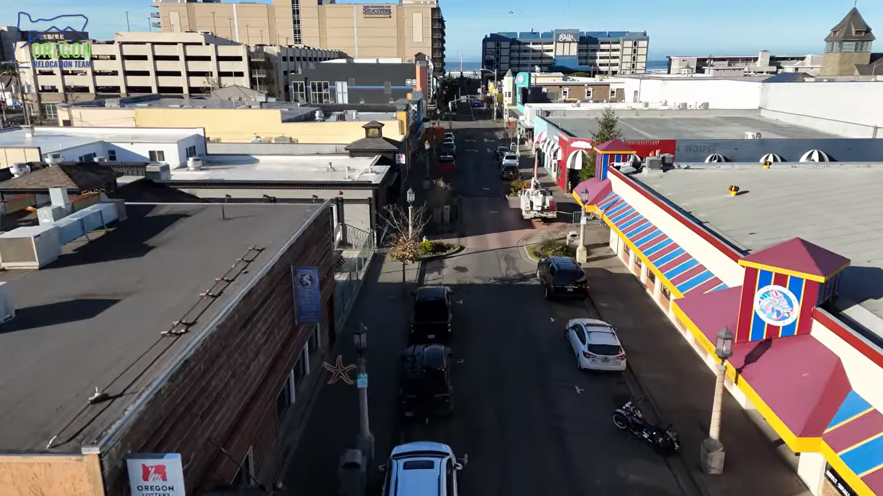 Aerial view down a Seaside street with shops cars and the ocean visible in the distance