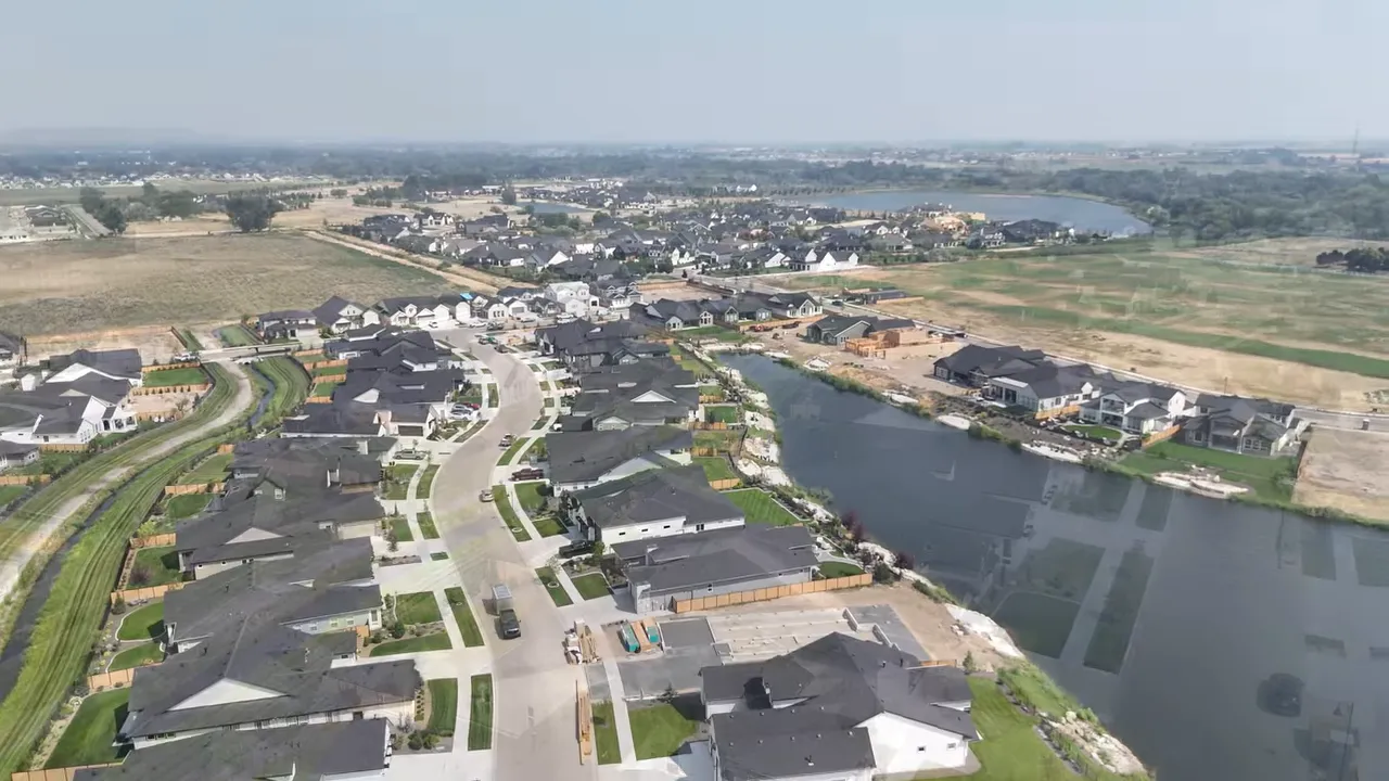 Aerial view of homes streets and a lake in River Park Estates