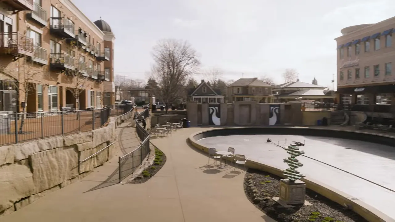Curved Creekside walkway beside water and apartment buildings