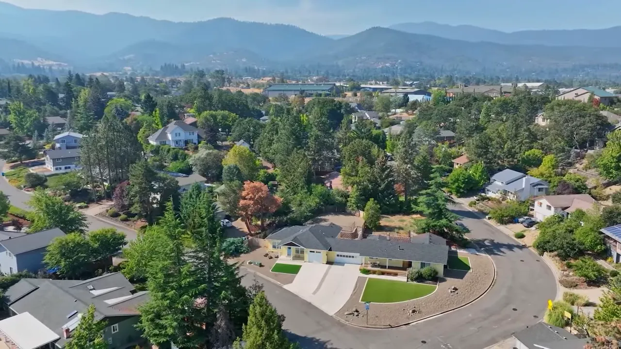 Wide aerial view of suburban homes and surrounding hills illustrating limited housing supply in Oregon