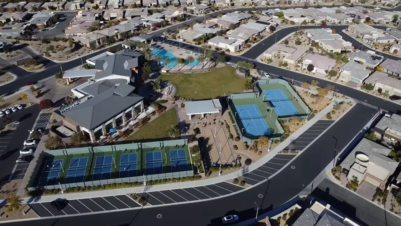 Aerial view of active adult community clubhouse pools and pickleball courts