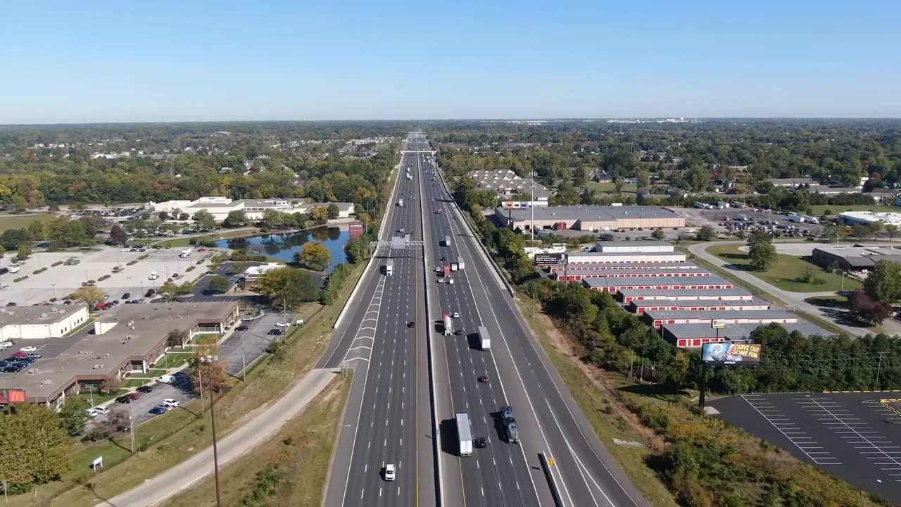 Aerial view of a straight multi-lane roadway in Westfield Indiana with traffic and surrounding neighborhoods