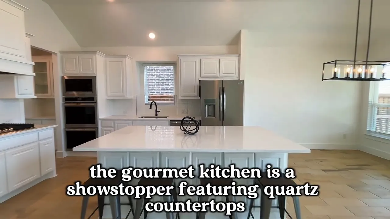 White kitchen with quartz island stainless refrigerator and dining area