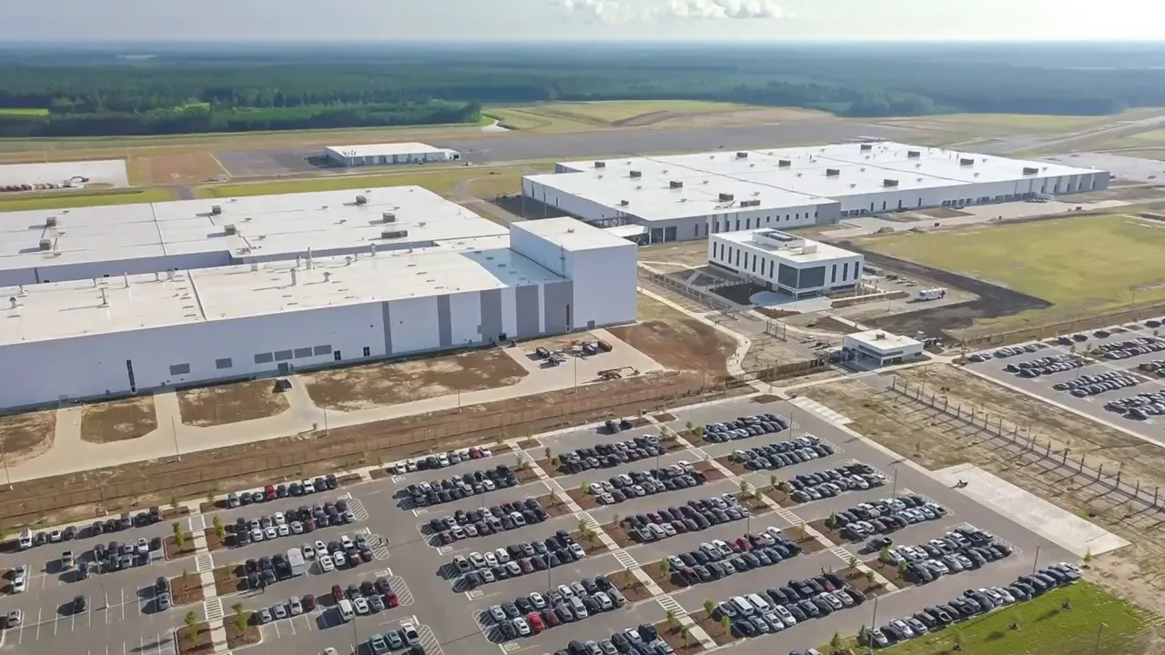 Large manufacturing facility and parking lot seen from above