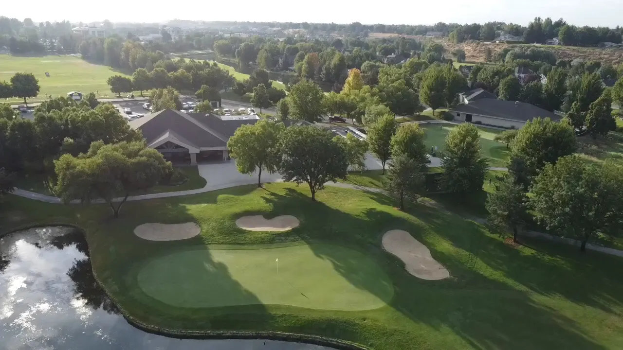 aerial view of a golf course with ponds and homes lining the fairways