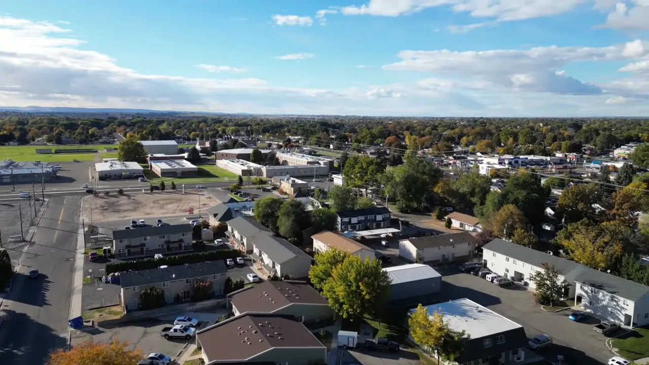 Aerial view of a residential neighborhood with a small commercial strip and tree-lined streets near Terra View