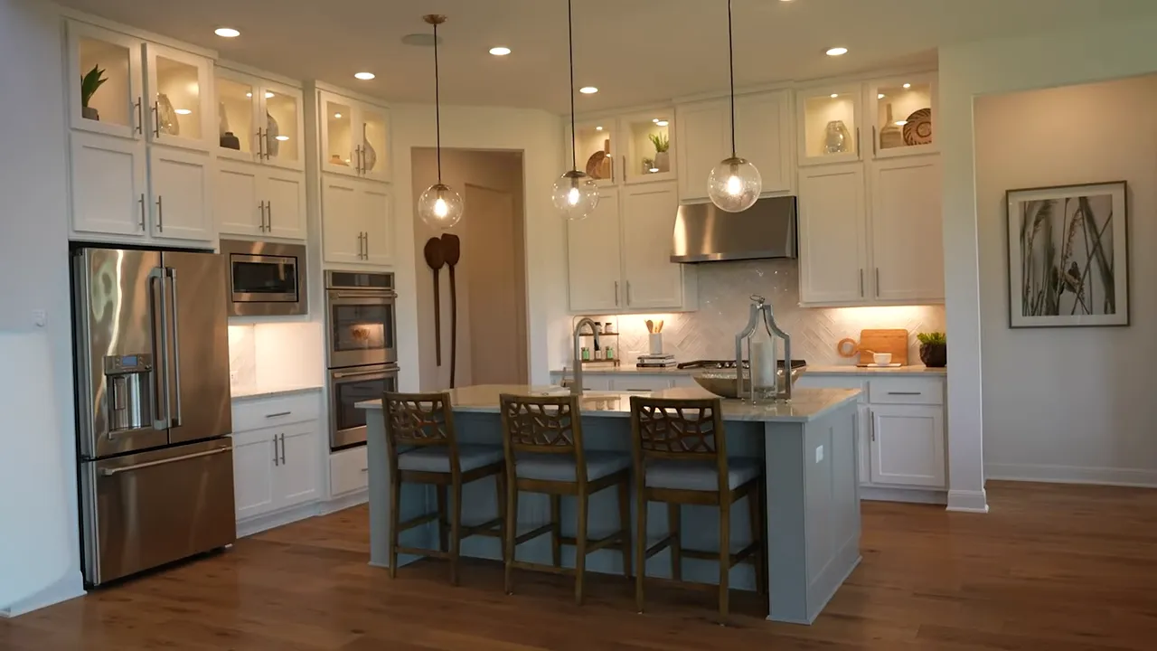 Bright kitchen with a large island pendant lights and stainless steel appliances