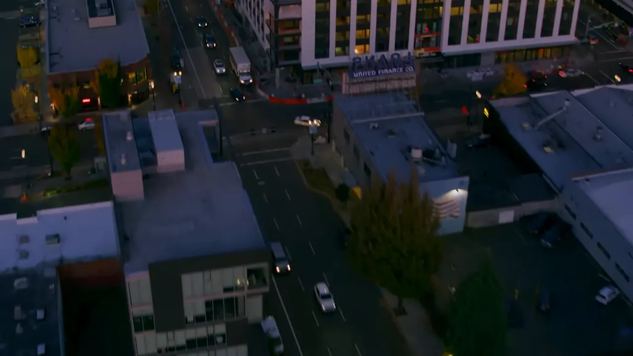 Dusk aerial view of city blocks and intersections with limited street lighting