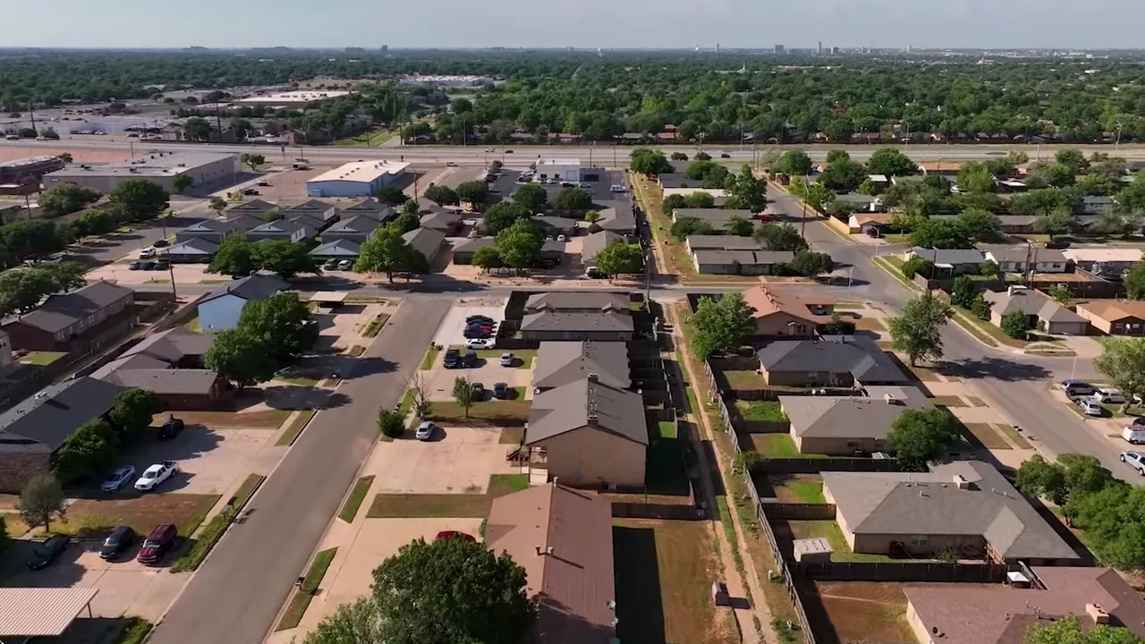 Aerial neighborhood view of single-family homes, yards, and streets in Lubbock.