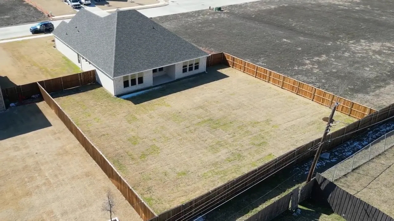 Aerial view of a large fenced backyard with covered patio in a new home near Dallas Texas