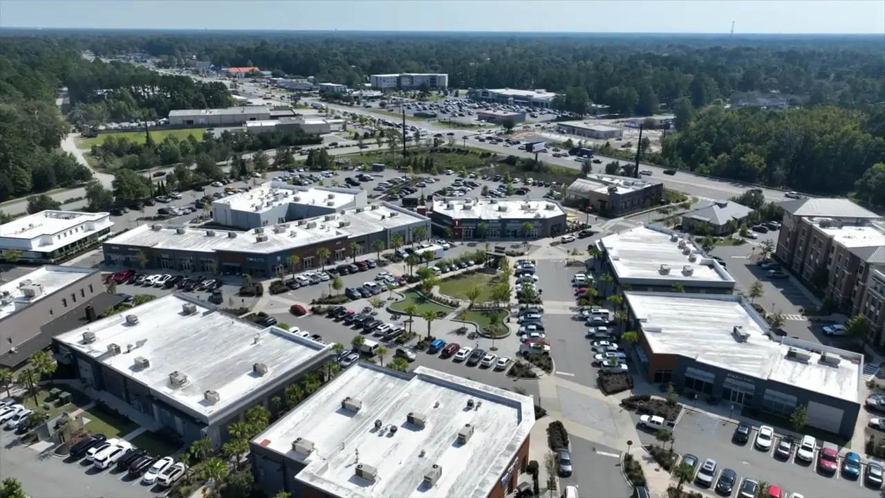 Clear aerial view of Nexton Square showing retail buildings, a landscaped plaza, and surrounding parking lots.
