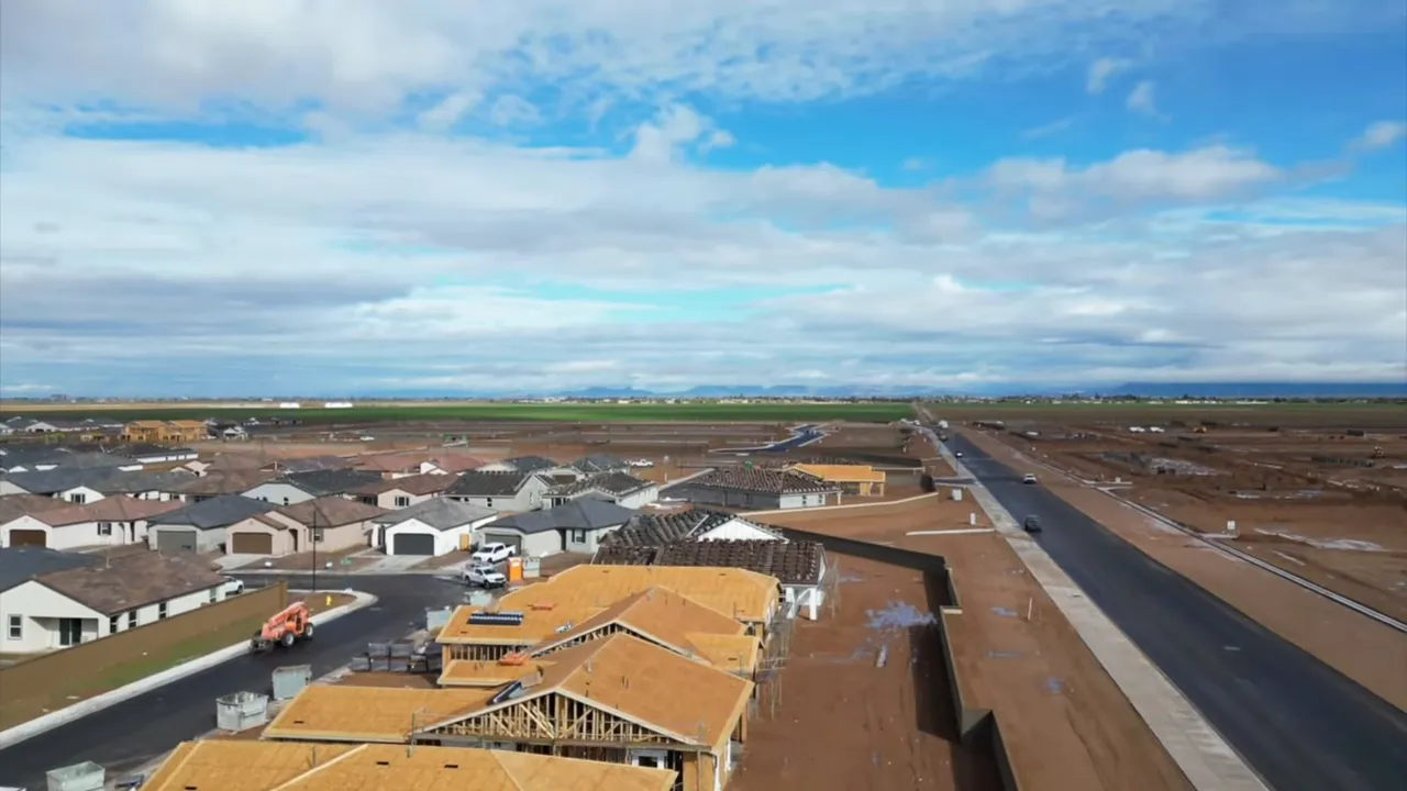 Aerial view of new homes under construction beside a newly paved road