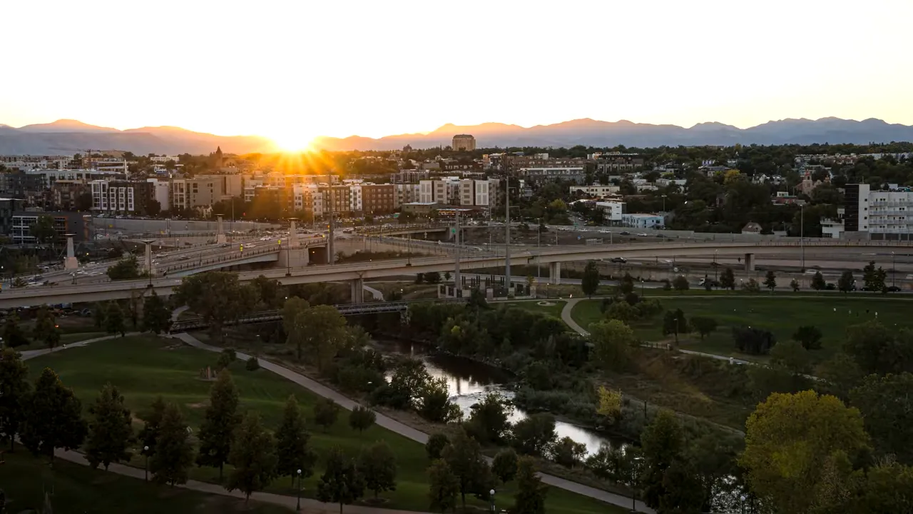 sunset cityscape with highways buildings and mountains in the distance