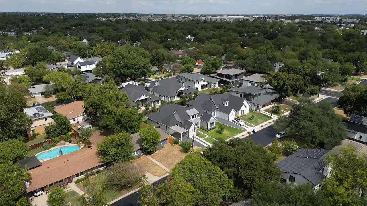 Aerial view of newer multistory homes beside smaller houses