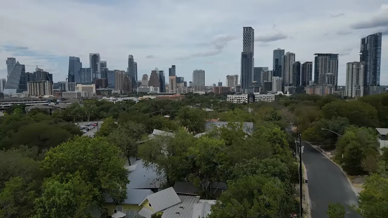 Downtown Austin skyline rising beyond trees and neighborhood rooftops