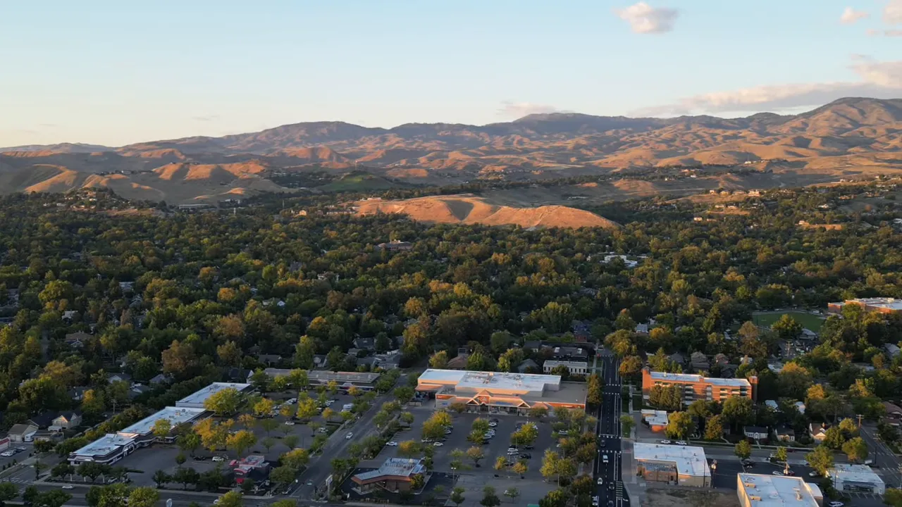 Aerial view of Boise neighborhoods with mountains in the distance at sunset