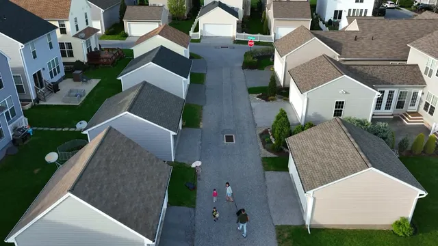 Aerial view of closely spaced newer suburban homes along a narrow street
