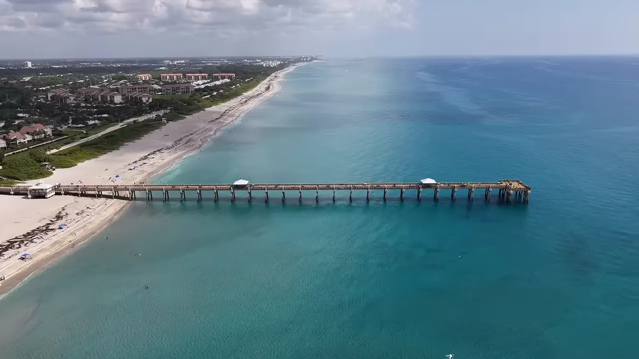 Aerial views of a beach pier marina and waterfront neighborhood