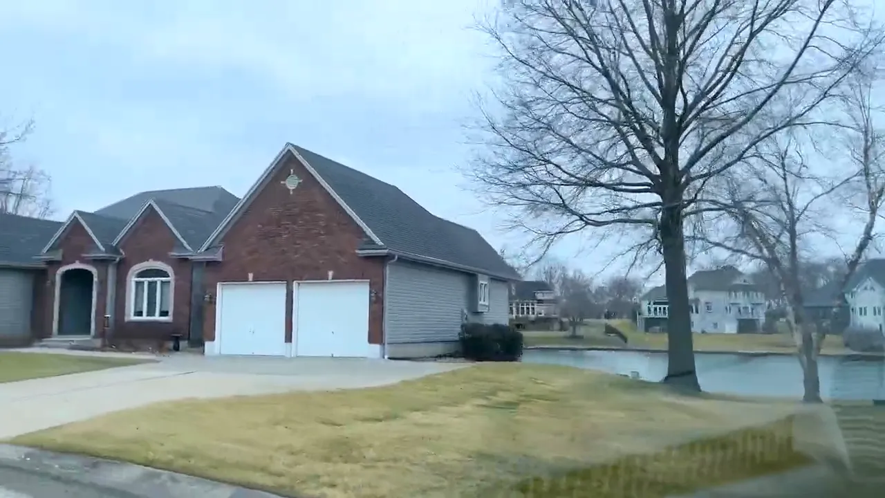 Lake Ridge home exterior showing brick house and garage with landscaped front yard in Warrensburg MO