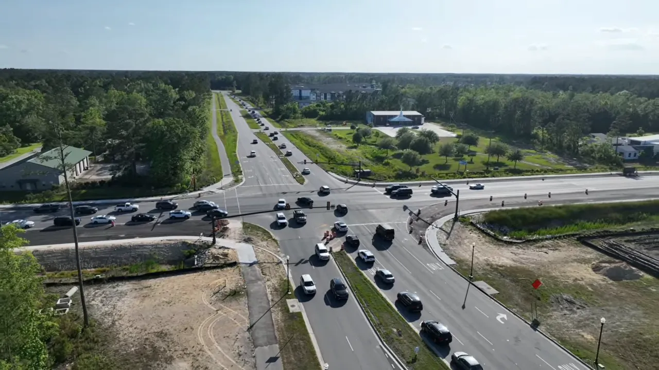 Aerial view of highways and traffic near a large residential community, highlighting commute considerations