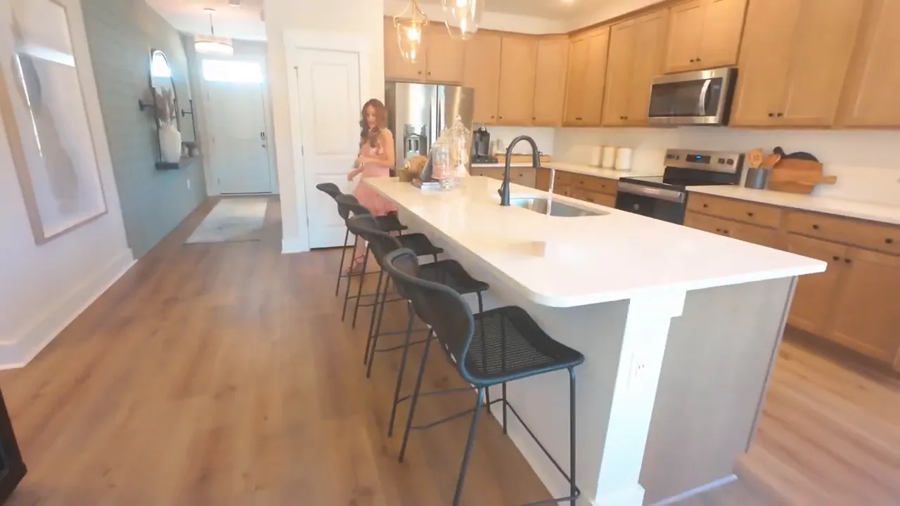 Kitchen with large island pendant lights wood cabinets and bar stools