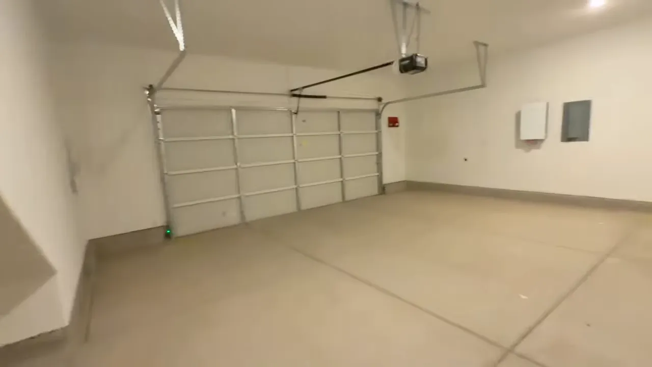 Spacious three-car tandem garage interior with finished concrete floor and built-in door tracks
