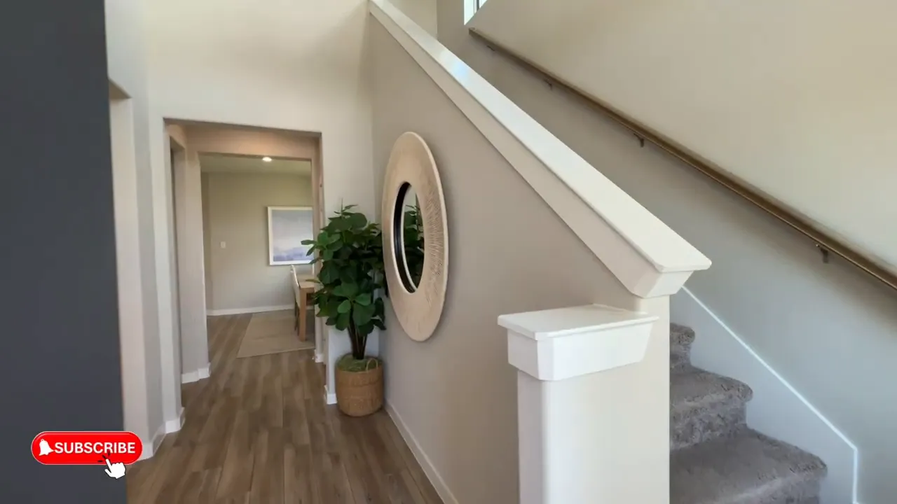 Entry hallway with staircase, wood look flooring, and decorative round wall mirror