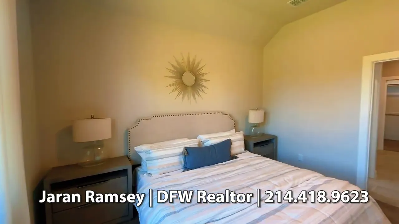 Primary bedroom with bed, bedside tables, and tall ceiling