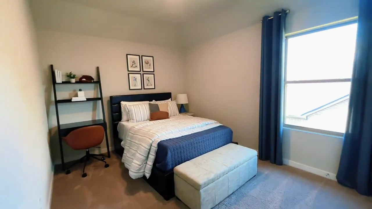 Secondary bedroom with bed, desk shelf, and window