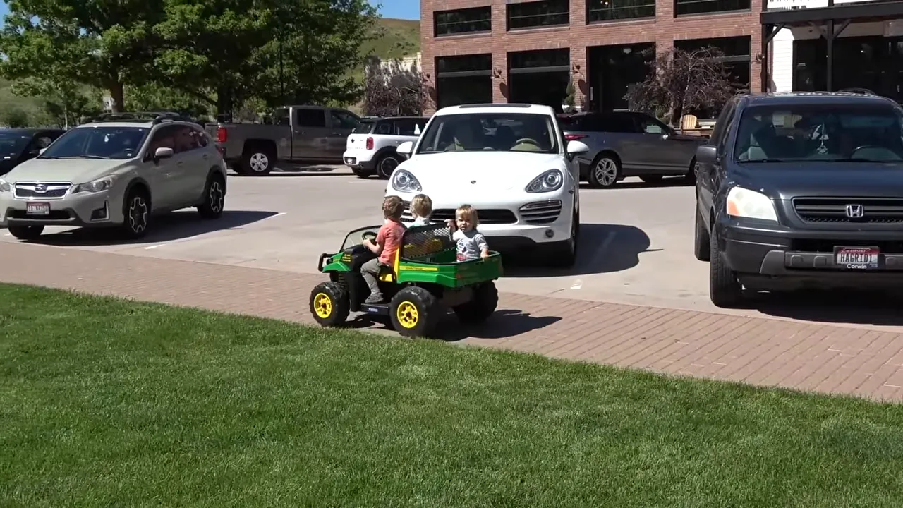 Children playing outdoors in a driveway with parked cars