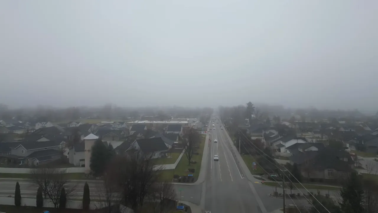 Aerial view of a Meridian roadway and neighborhoods under thick gray haze