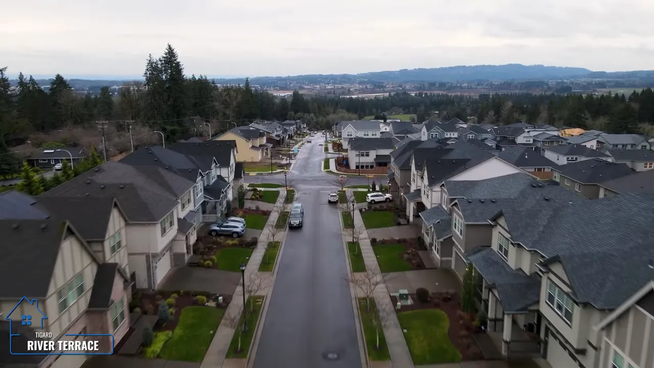 Aerial view down a residential street lined with newer homes and sidewalks