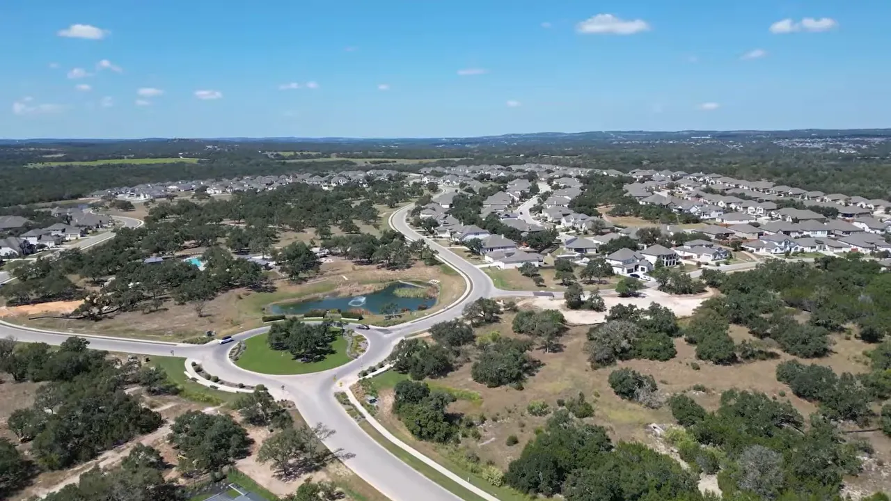 Aerial view of a Dripping Springs community with ponds and curved roads