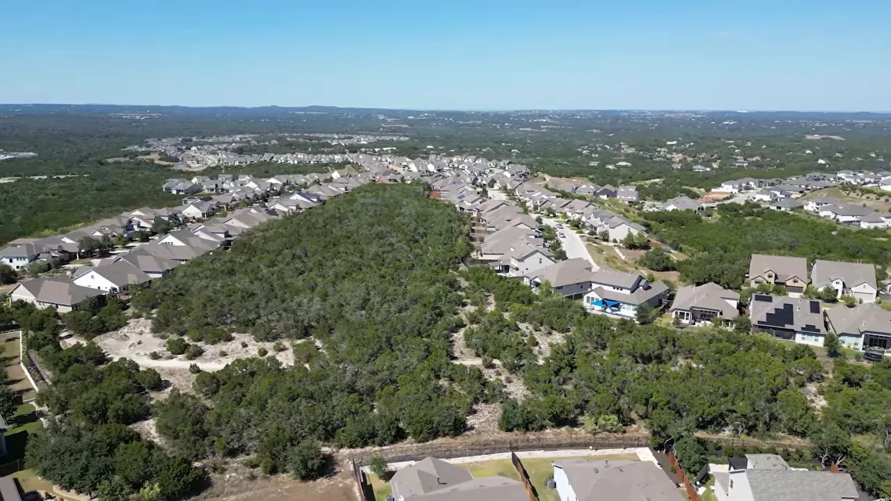 Aerial view of neighborhoods and green Hill Country landscape in Dripping Springs, Texas