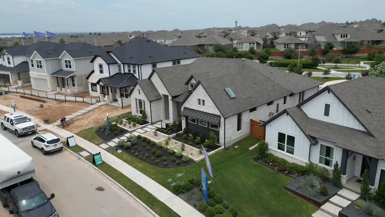 Aerial view of rows of newly built homes and active construction in the community