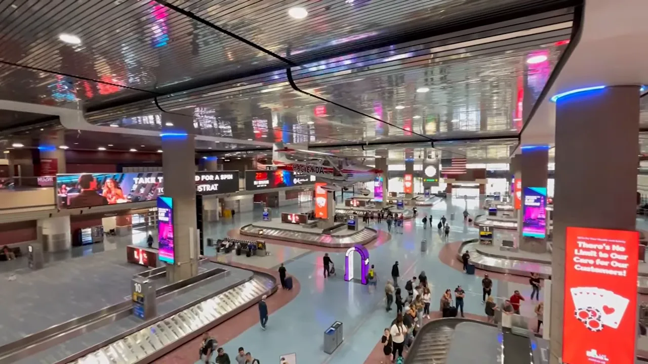 Busy airport baggage claim hall with digital displays